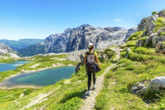 Tourist enjoying the scenic view of the tre cime di lavaredo and alpine lakes in the italian