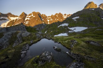 Rocky mountain peaks with reflection, small pond in moor landscape at Trollfjord Hytta, mountain