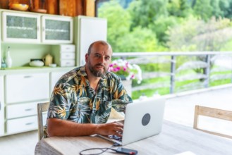 Digital nomad working on laptop in a mountain chalet, enjoying the freedom of remote work and a