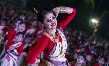 An instructor dance as participants follows the dance step in a Bihu dance workshop ahead of