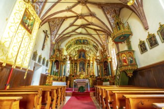 Featuring a richly decorated altar, vibrant frescoes, and a traditional wooden pulpit, the interior