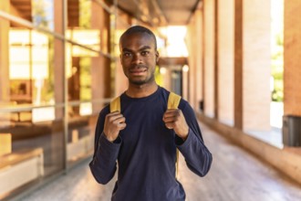 Frontal portrait of a young African student standing looking at camera at the university