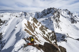 Mountaineer belaying on a steep snow slope, belaying on a rope, ascent to the summit of Piz