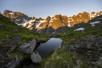 Rocky mountain peaks with reflection, small pond in moor landscape at Trollfjord Hytta, mountain
