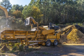 Full length photo of heavy machinery transporting waste outside a recycling plant