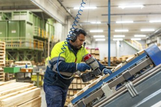 Side view three quarter length photo of a caucasian man worker arranging pallets to reuse it in a