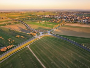 Shaded fields and a roundabout near a village at sunset, Nagold, Black Forest, Germany, Europe