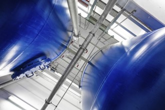 View between two large blue metal tanks with a grid attached to the top, ENCW Netze Calw