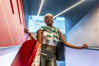 Low angle view portrait of a stylish african woman with short hair coming down an escalator