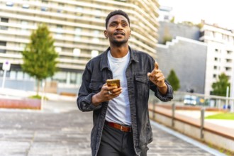 African man walking along the city using gps app to find a direction