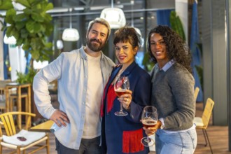 Portrait of happy friends holding beer glasses and smiling at camera during night party outdoors