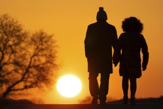 A couple walks along a country lane near Frankfurt am Main at sunset, Frankfurt am Main, Hesse,
