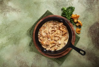 Fried chanterelle mushrooms, in cream sauce, in a cast-iron pan, homemade, no people