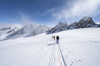 Ski tourer with rope, rope team on the Vadret da Porchabella glacier on the ascent to the summit of
