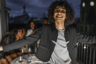 Man dancing happily during night party in a rooftop with multiracial friends