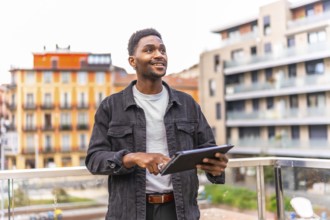 African man using tech holding digital tablet in the city
