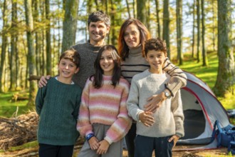 Portrait of a happy caucasian family with three children enjoying nature and camping together