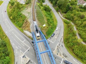 Railway train crosses a bridge with roads and vehicles, track construction, rail delivery for