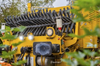 Yellow machine, partly covered by leaves, showing technical details, tamping machine, Hermann