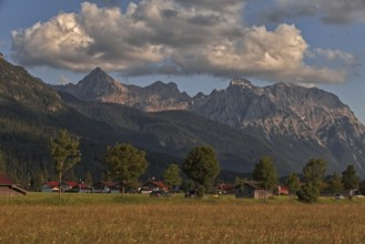 Mountains in the background of a small village with clouds in the sky in a natural landscape,