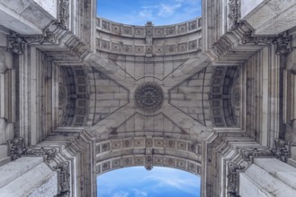 View of ornate stone arch pattern with symmetrical details and clear blue sky in the background,