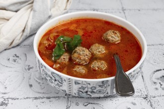 Romanian soup with meatballs, vegetable soup with meatballs, tiled table, homemade, no people