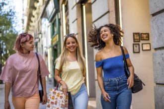 Three young female friends enjoying day shopping at the city