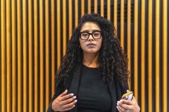 Professional latin businesswoman looking at camera indoors in a modern building