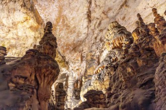 Breathtaking view of illuminated stalagmites and stalactites forming stunning geological structures