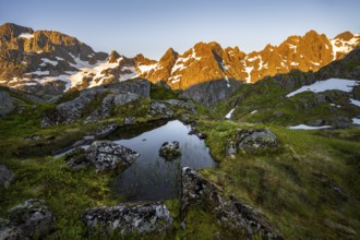 Rocky mountain peaks with reflection, small pond in moor landscape at Trollfjord Hytta, mountain