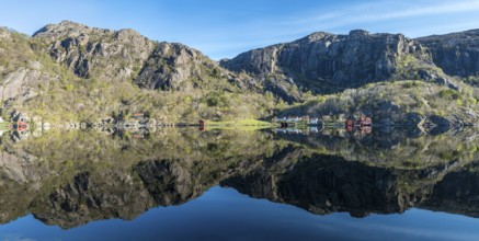 Near Ana-Sira at the norwegian southern coast, lonely houses at the foot of a rock formation are