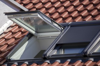 New roof windows with roller shutters on a red tiled roof