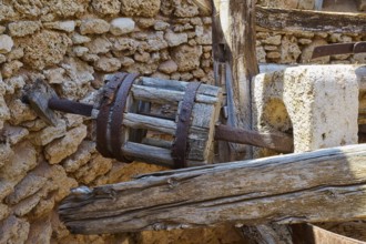 Close-up of a wooden cogwheel component in an old stone building ruin, windmill, ruin, near Lindos,