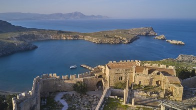 Drone shot, Acropolis of Lindos, Late afternoon light, Rock fortified historical site above a calm