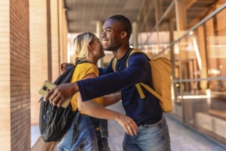 Multiracial students smiling happily while embracing and greeting at the university campus