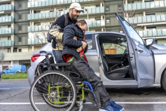 Man assisting disabled friend in getting out of a car parked on an urban street, showcasing the