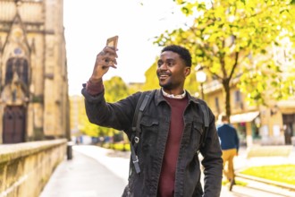 African man taking photos of a city while walking and visiting it during sunset