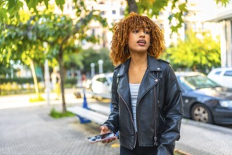 Distracted beauty latin woman listening to music with earbuds and smartphone outdoors in the street