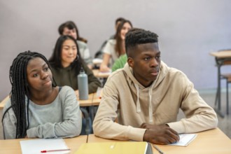 Multi ethnic university students listening attentively to a lecture in a classroom setting, focused