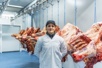 Caucasian adult female manual worker standing proud in a meat processing factory