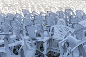 Seating for outdoor event, rows of chairs, overturned garden chairs made of plastic, plastic,