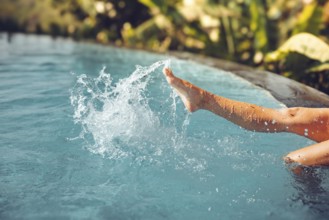 Beautiful female legs splashing in the pool, Bali, Indonesia, Asia