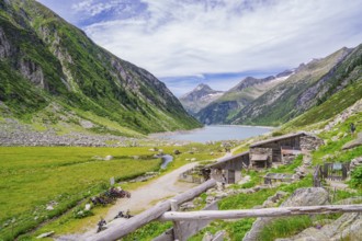 View of a mountain landscape with a lake, huts and a path through a green meadow, Klein Tibet,