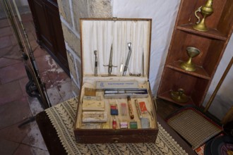 An old toolbox with medical instruments and sewing utensils on an antique wooden shelf, Simantiris
