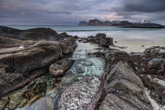 Rocks and beach in front of Bergen, sea, surf, spray, clouds, winter, Flakstadoya, Lofoten, Norway,
