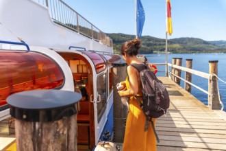 A female tourist boarding a boat on Lake Titisee in the Black Forest of Germany