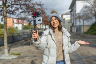 Beauty caucasian female vlogger talking to the audience recording online video at city