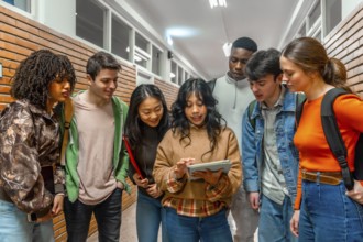 Diverse group of college students collaborating on a project, using a digital tablet in a