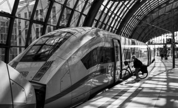 Black and white photograph, traveller with bicycle at Berlin Central Station, Berlin, Germany,