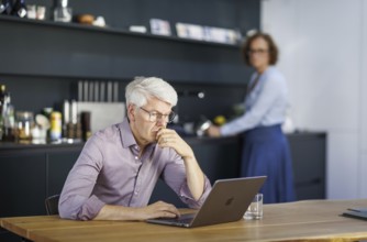 Symbolic photo on the subject of division of labour for couples in the household. A man sits in a